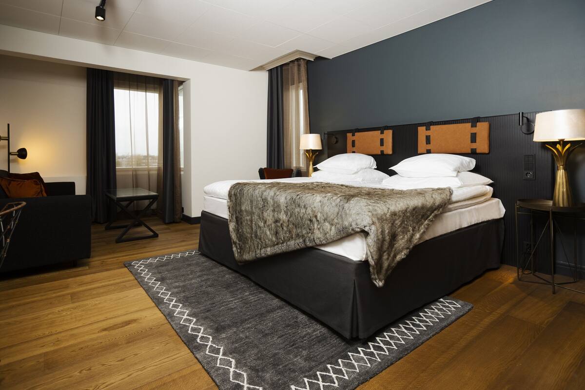 Une chambre d’hôtel moderne avec un grand lit, un bureau et une vue sur la ville.