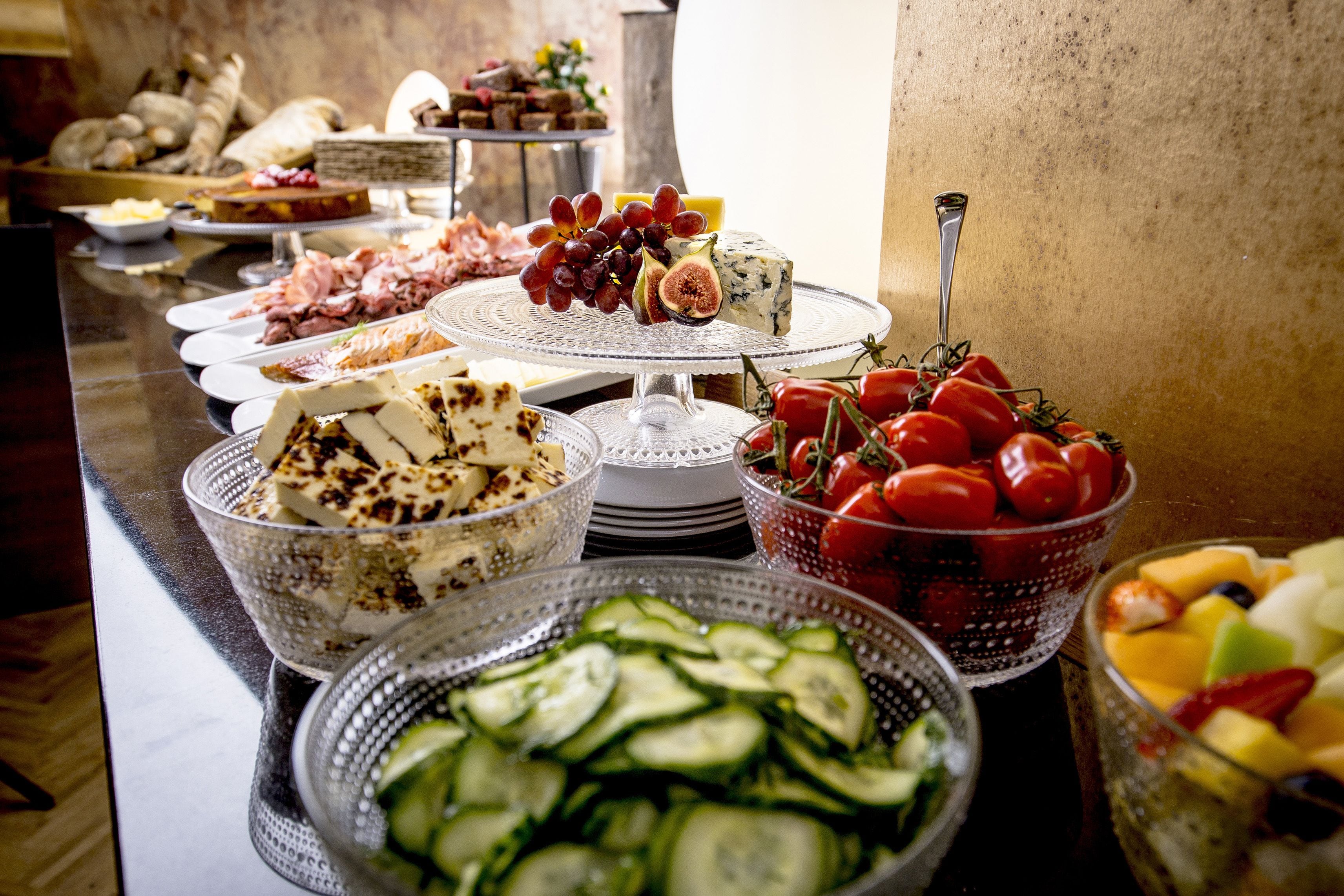 Ein reichhaltiges Buffet mit Käse, Obst, Gemüse und Fleisch.