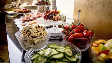 Ein reichhaltiges Buffet mit Käse, Obst, Gemüse und Fleisch.