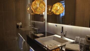 A modern bathroom with a large mirror, a sink, and a towel rack.