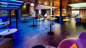 A modern lounge area with a staircase, seating, and a bar. - Klaus K Hotel (Helsinki)