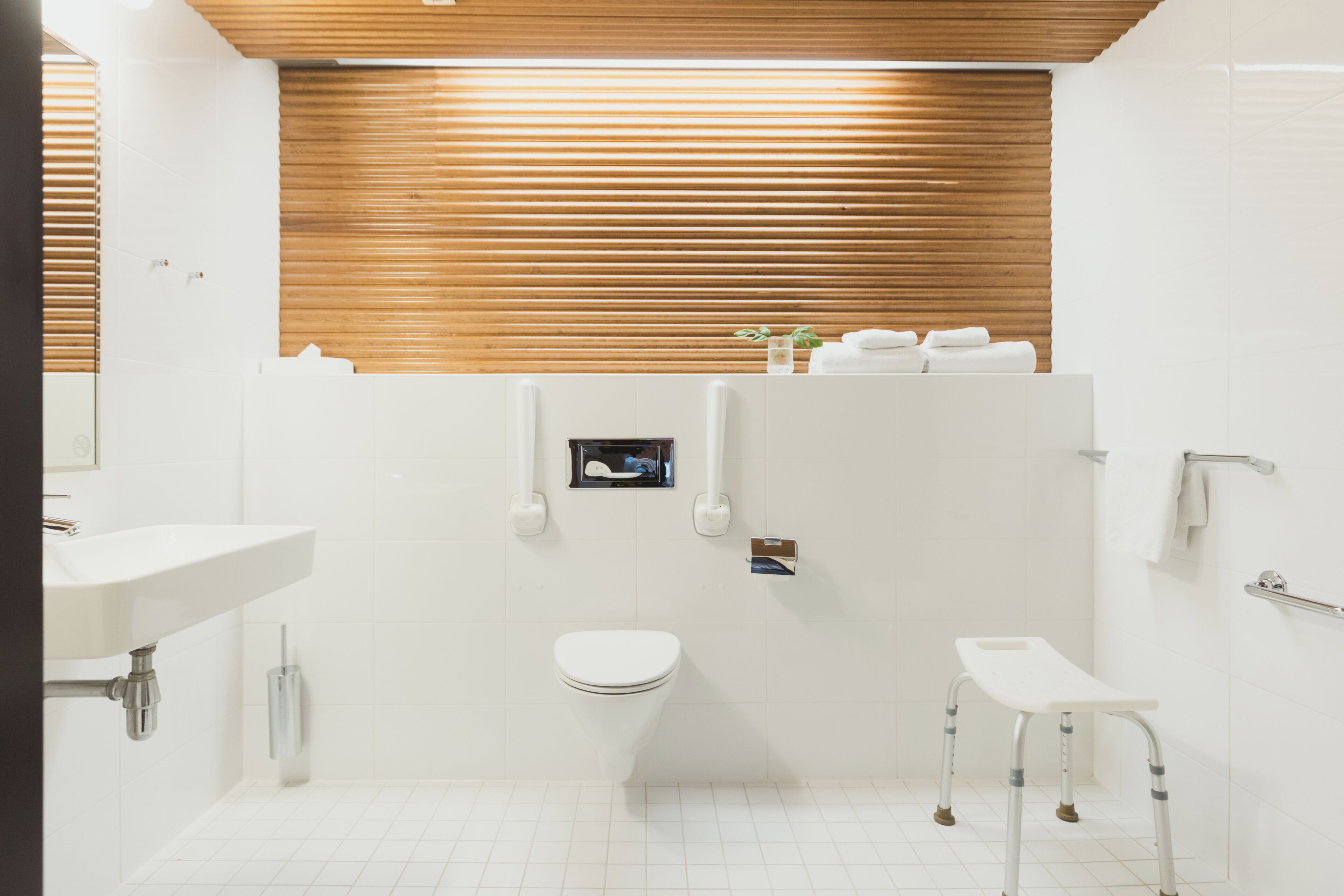 Ein modernes Badezimmer mit Waschbecken, Toilette und Dusche, alles in Weiß.