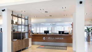 A reception area with a wooden reception desk, a glass display case, and a tiled floor.