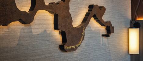 A wall-mounted metal sculpture with inscriptions.