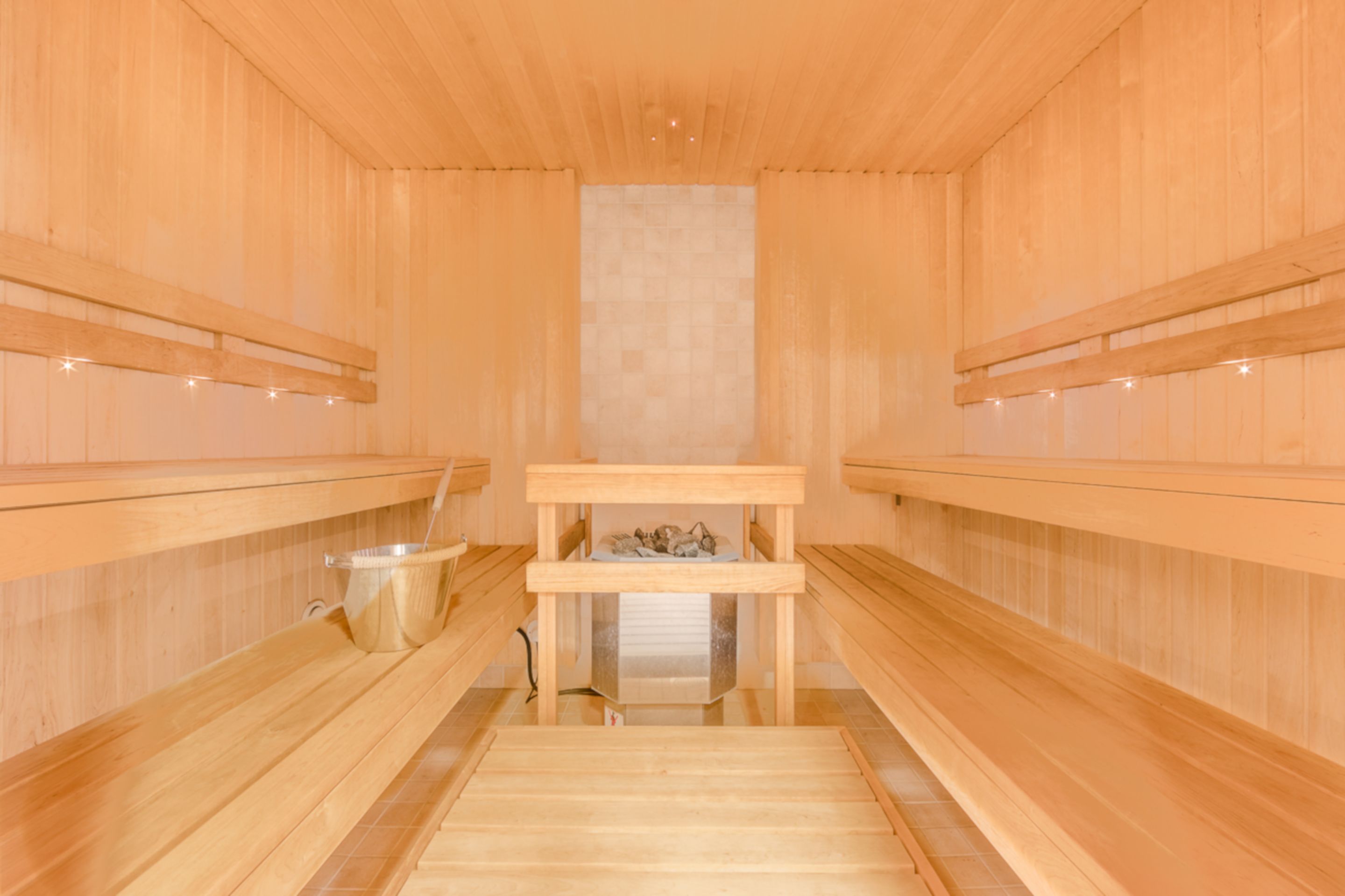 Een sauna met houten banken en een centrale tafel.