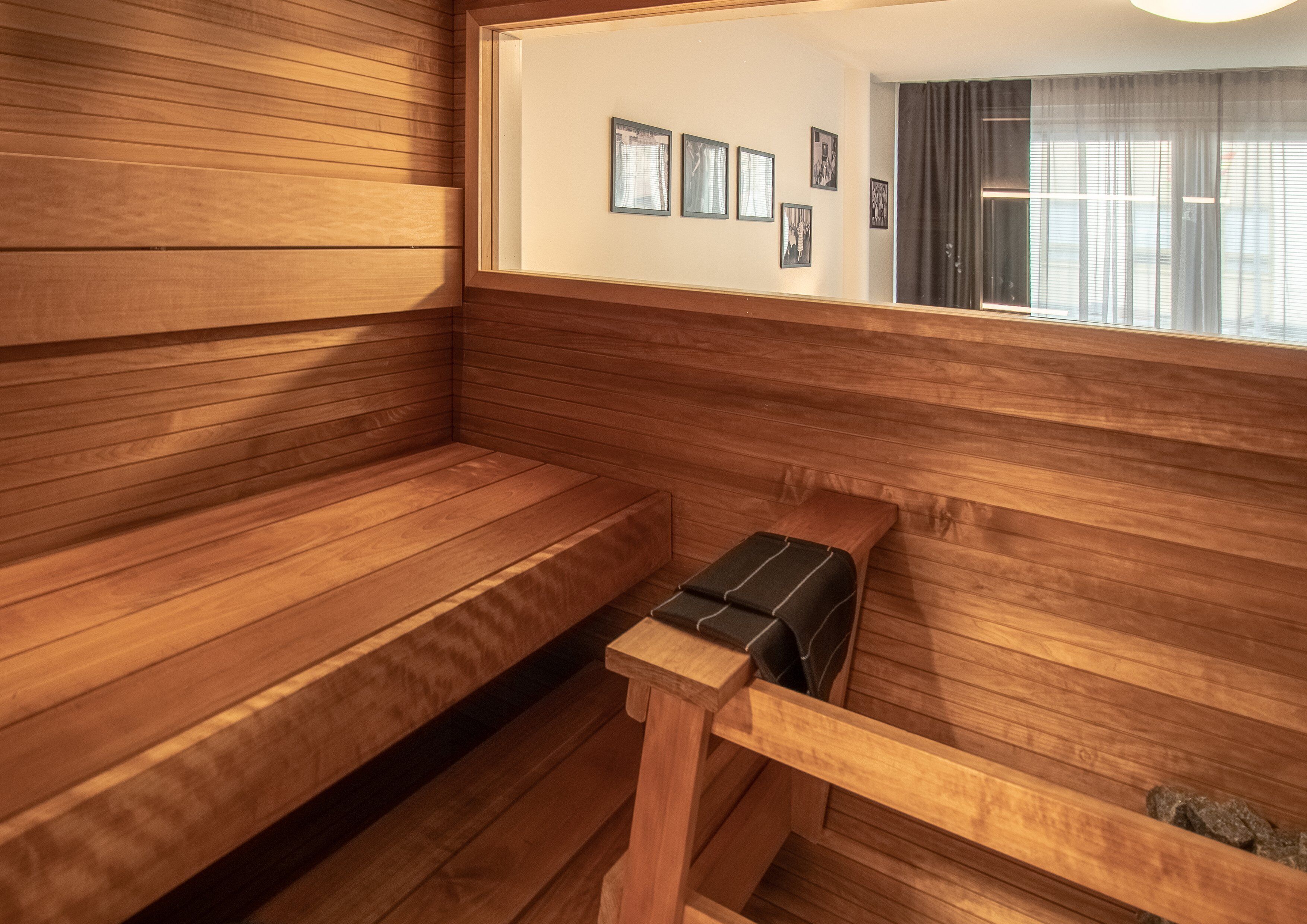 Una sauna amb grans bancs de fusta i un banc amb tovallola.