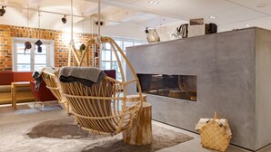 Un interior moderno con una silla de mimbre, una chimenea y una pared de ladrillo.