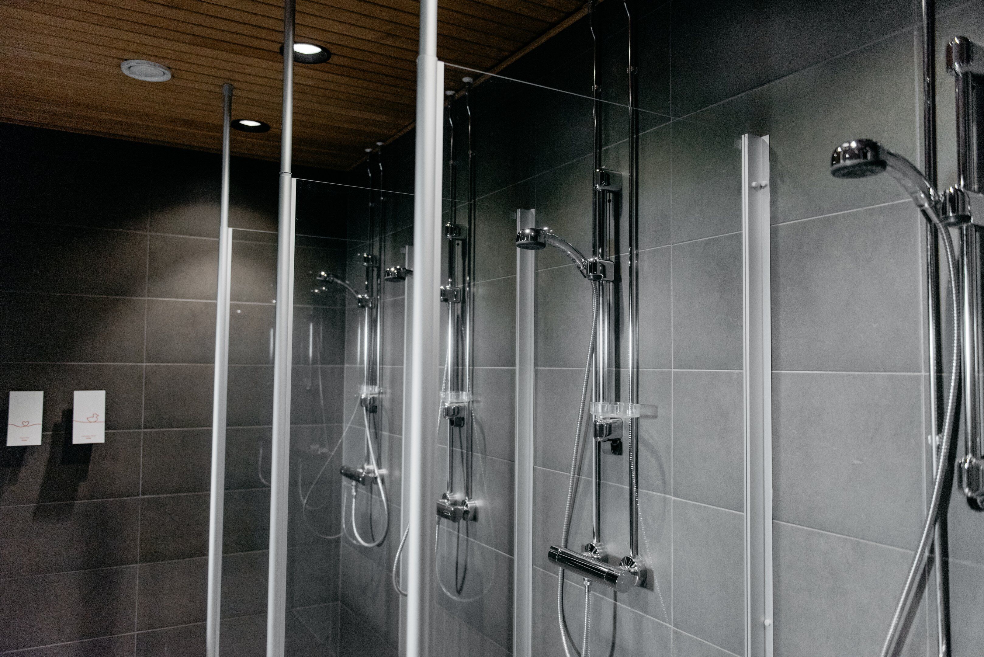 A modern shower area with multiple showerheads and glass panels.