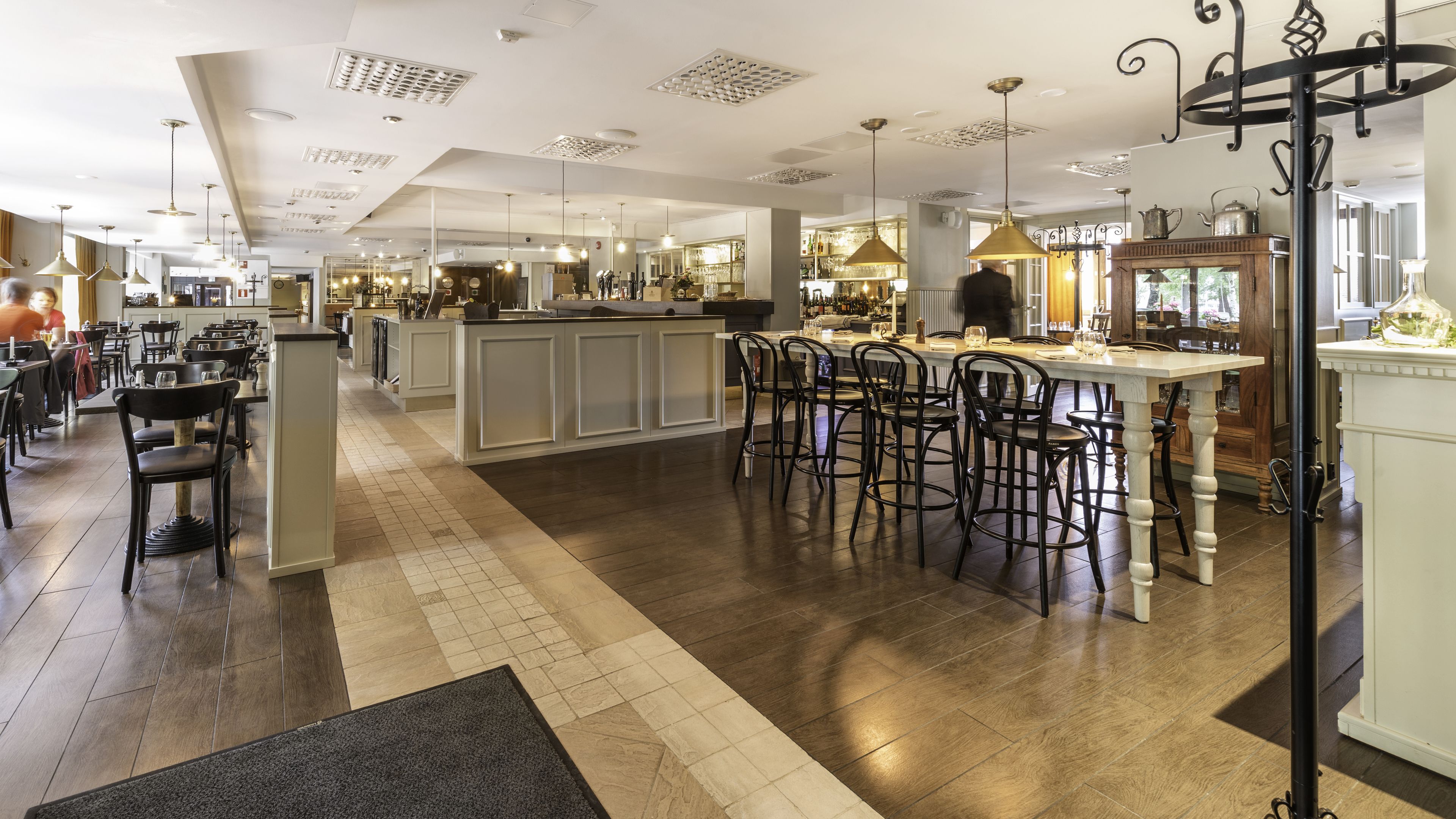 A spacious restaurant with a central bar area, multiple seating options, and a modern interior design.