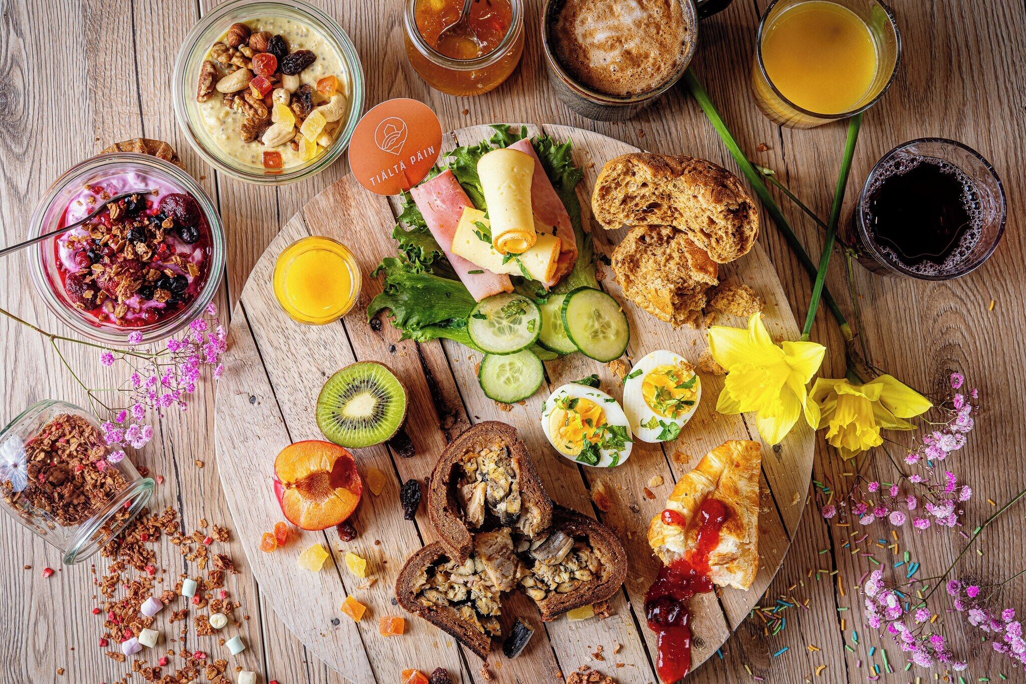 A breakfast spread with various foods and drinks on a wooden table.