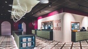 Un interior moderno con una isla central, suelo estampado e iluminación colgante.