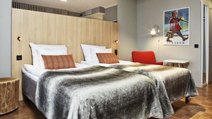 Una habitación de hotel moderna con una cama grande, una mesita y un cartel en la pared.
