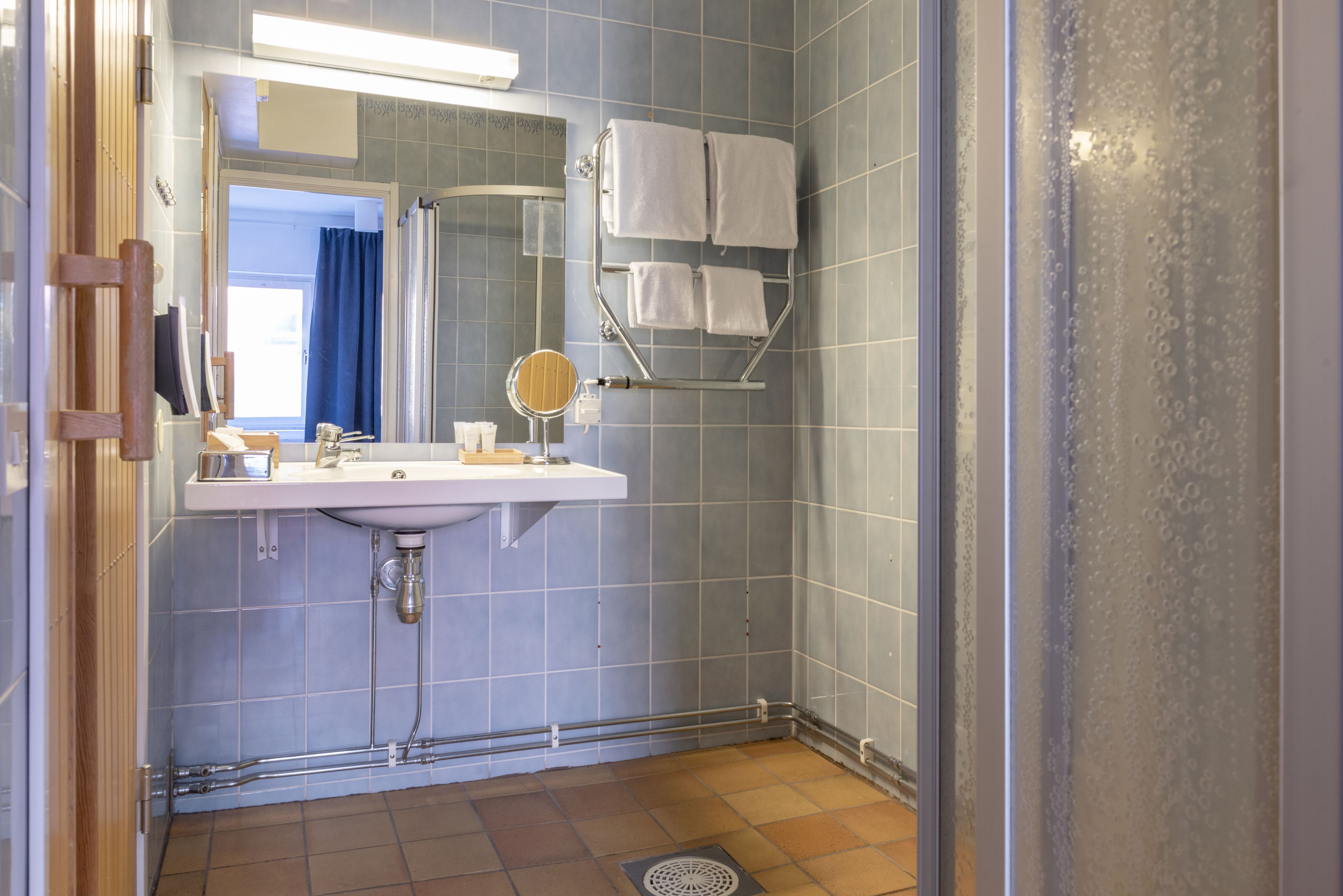 A bathroom with a sink, mirror, and towel rack.