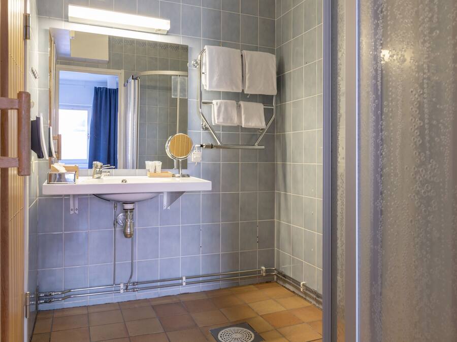 A bathroom with a sink, mirror, and towel rack.