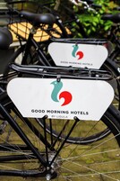 Una bicicleta con un letrero blanco que dice "GOOD MORNING HOTELS BY LIGULA".