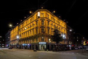 Un edificio histórico con entrada en esquina, varias ventanas y un letrero que indica un hotel.
