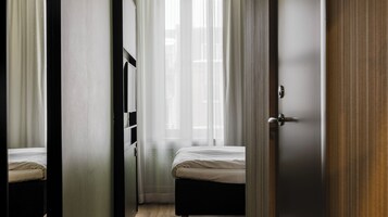 A bedroom with a bed, a wardrobe, and a door.