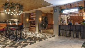 Ett receptionsområde med en bar, sittplatser och en incheckningsdisk.