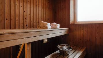 Una sauna de madera con un banco y un cubo de hielo.