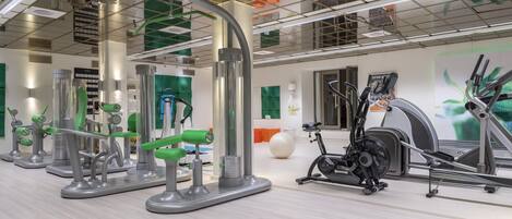 Un gimnasio moderno con diverso equipo de ejercicio, que incluye cintas de correr y máquinas de pesas.