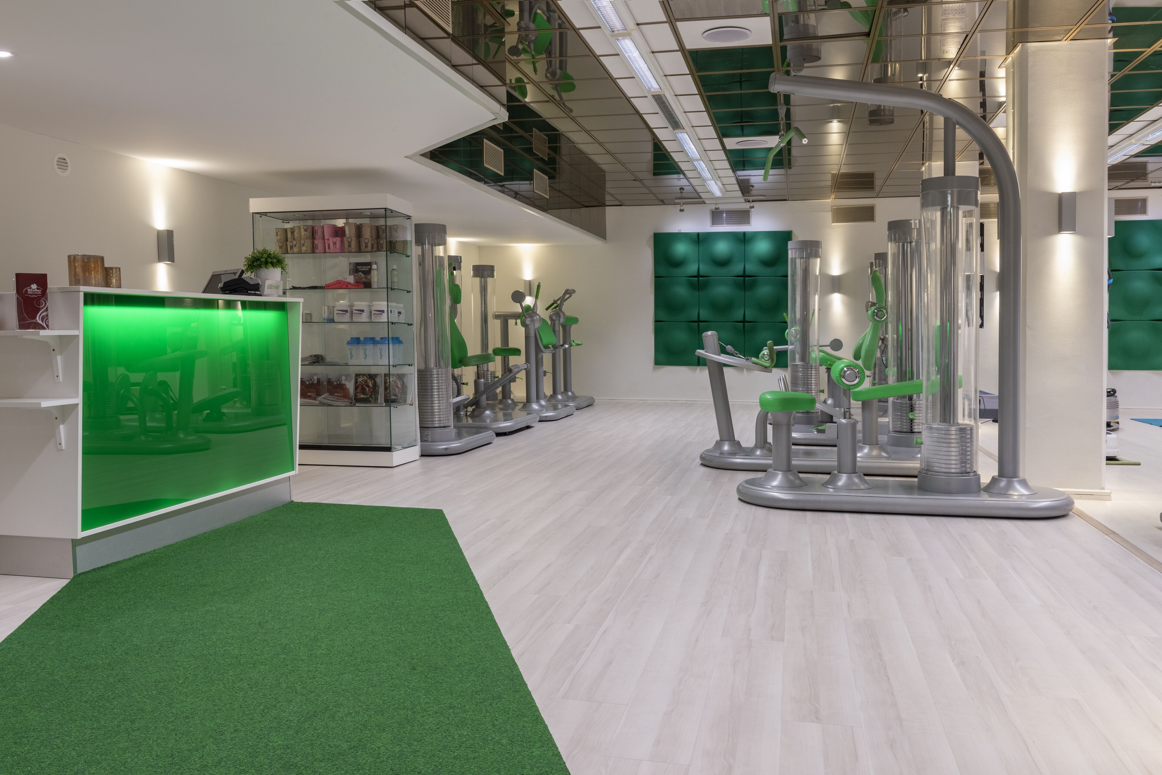 A modern dental clinic interior with a reception area, green artificial grass, and various dental equipment.
