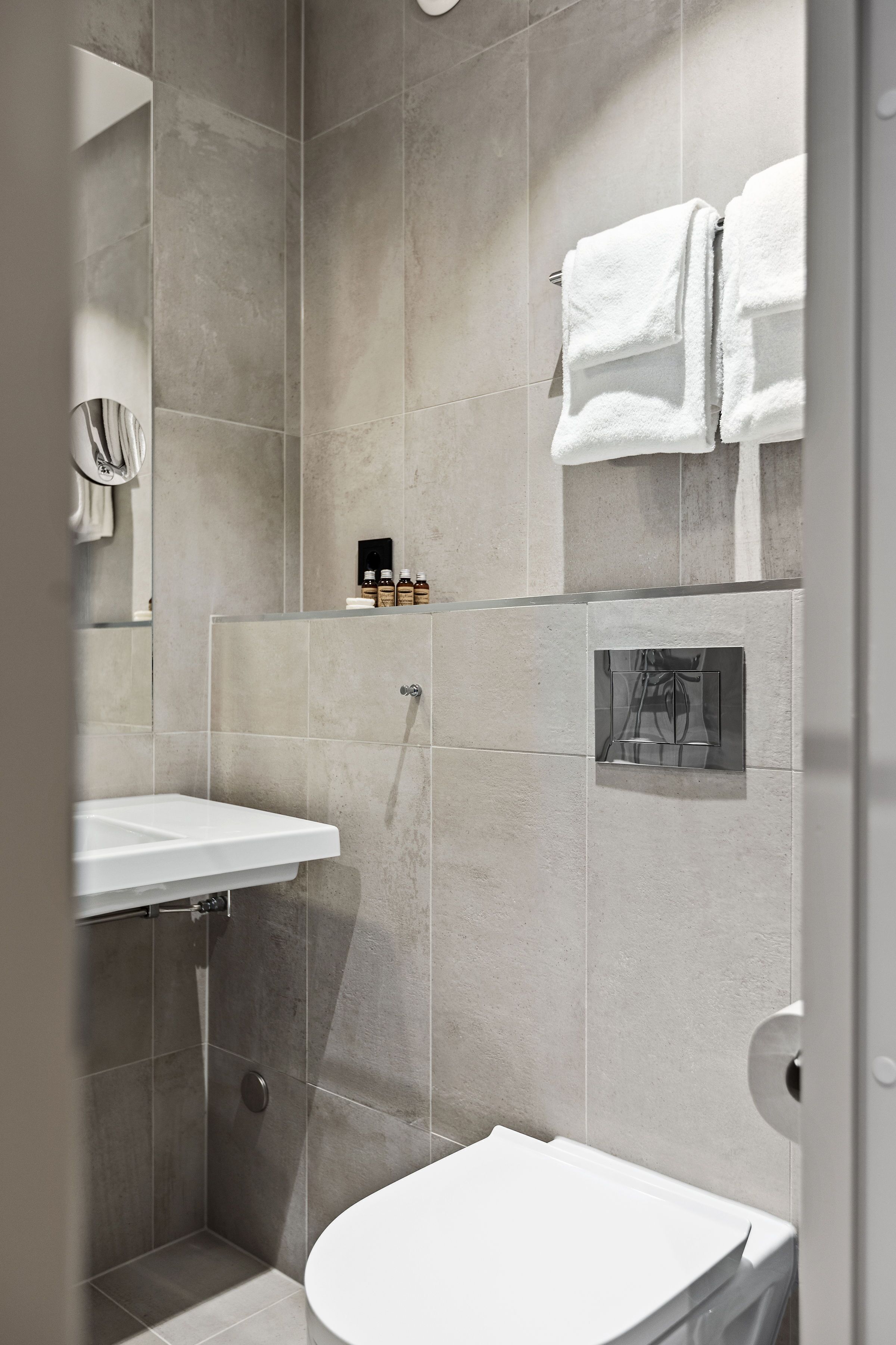 A modern bathroom with a shower, toilet, and sink.