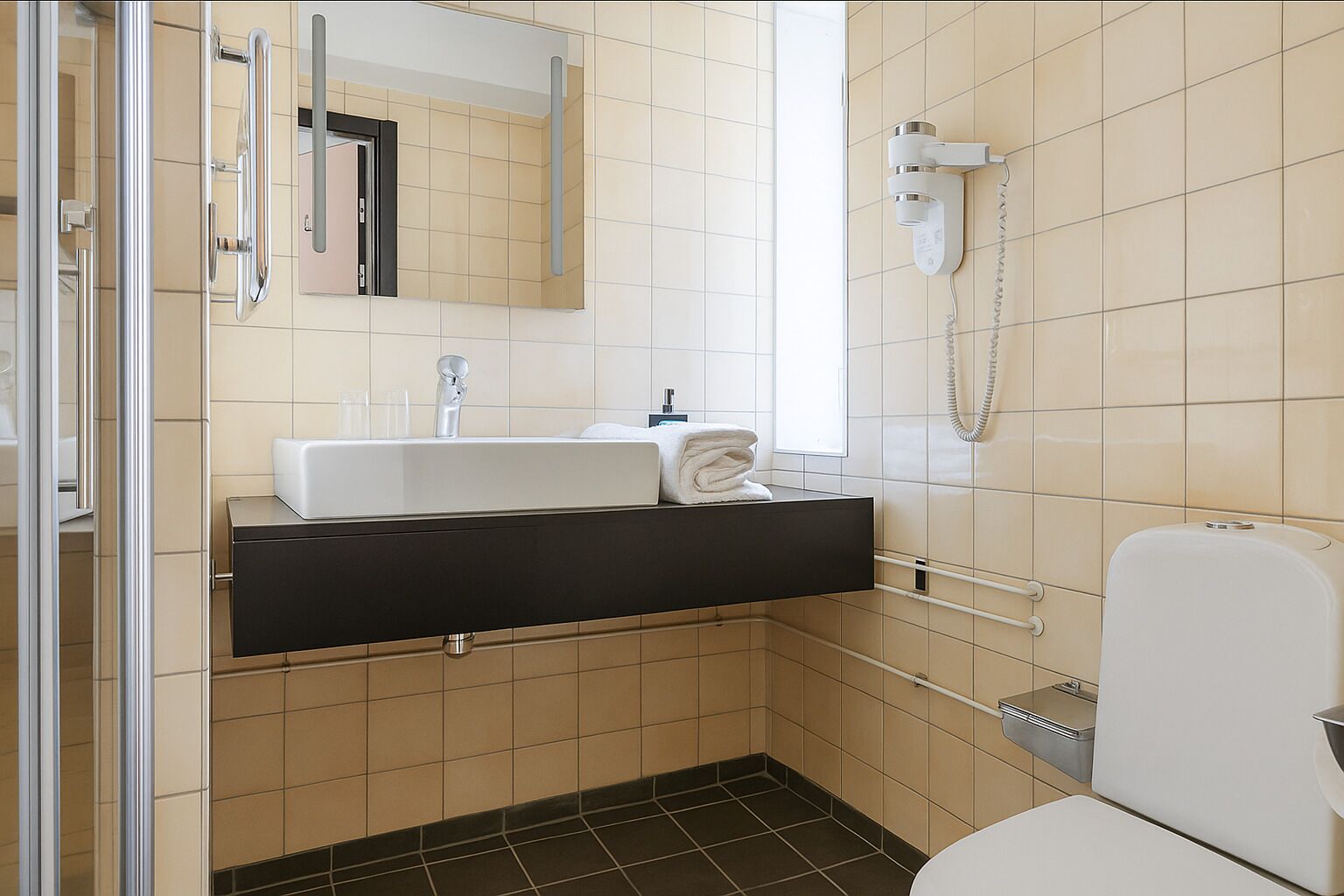 Un baño moderno con lavamanos, espejo e inodoro.