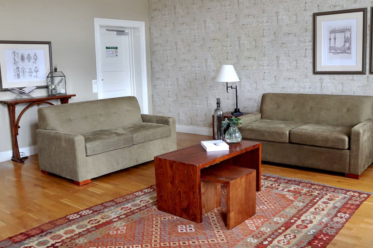 A living room with two sofas, a wooden coffee table, and a patterned rug.