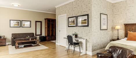 A bedroom with a bed, a desk, a leather chair, a sofa, and a wooden cabinet.