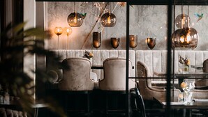 Un comedor acogedor con papel tapiz estampado, lámparas colgantes y asientos cómodos.