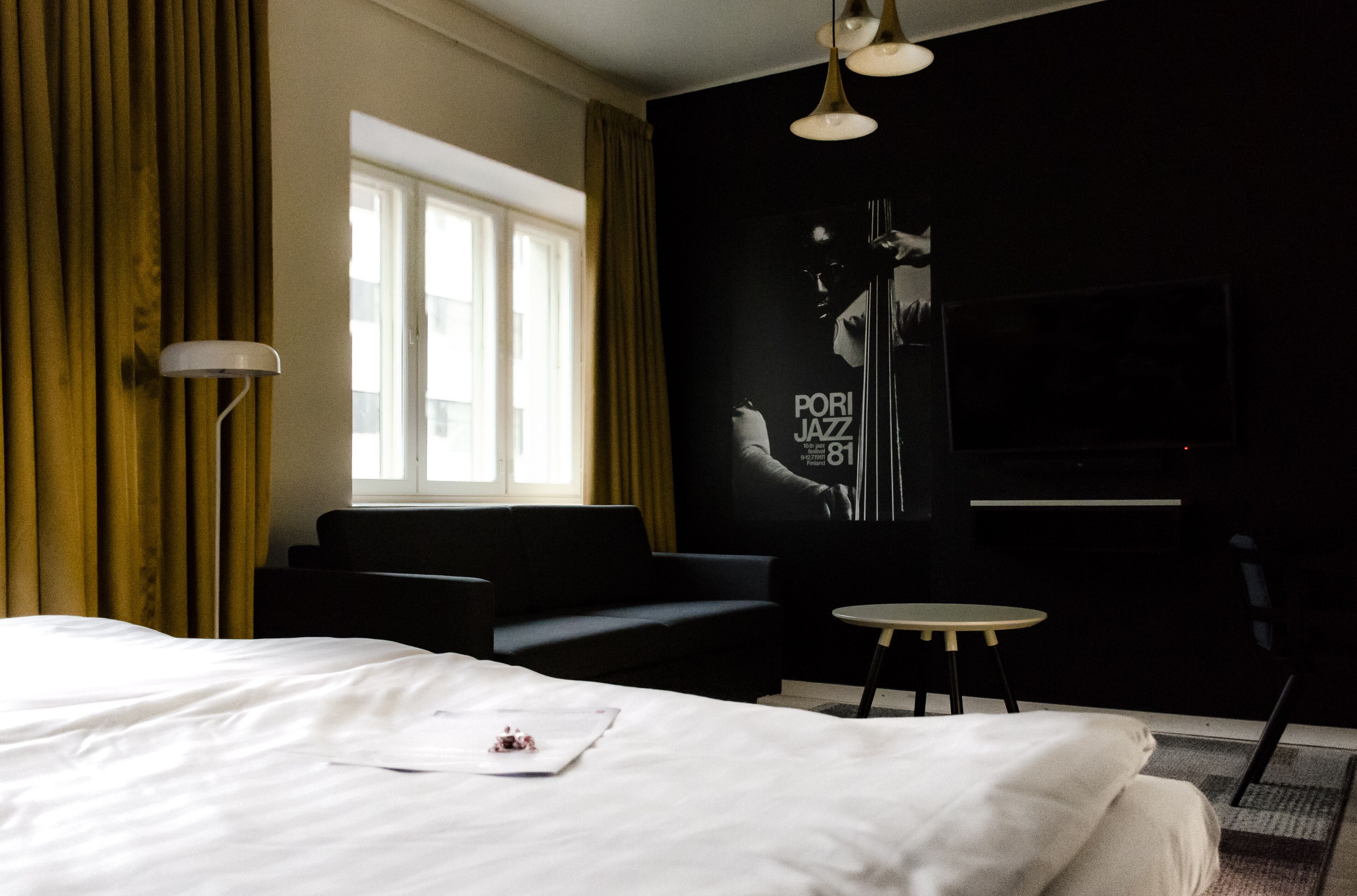 Une chambre d’hôtel avec un grand lit, un canapé, une petite table et un téléviseur.