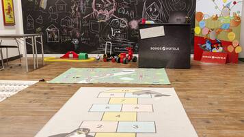 Welcome to SOKOS HOTELS, where families can enjoy a playful and creative space with children's play areas and a chalkboard wall.