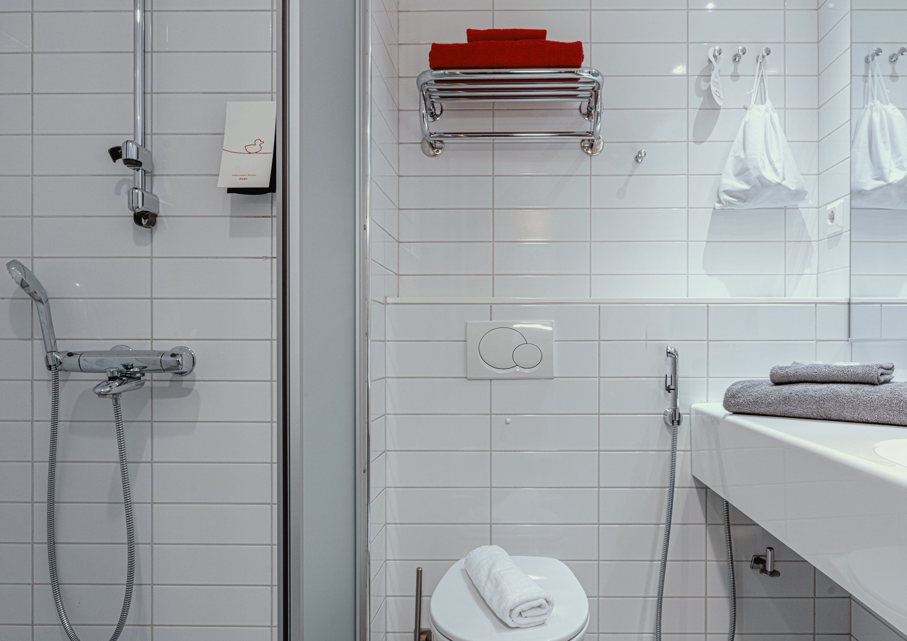 A modern bathroom with a shower, toilet, and sink.