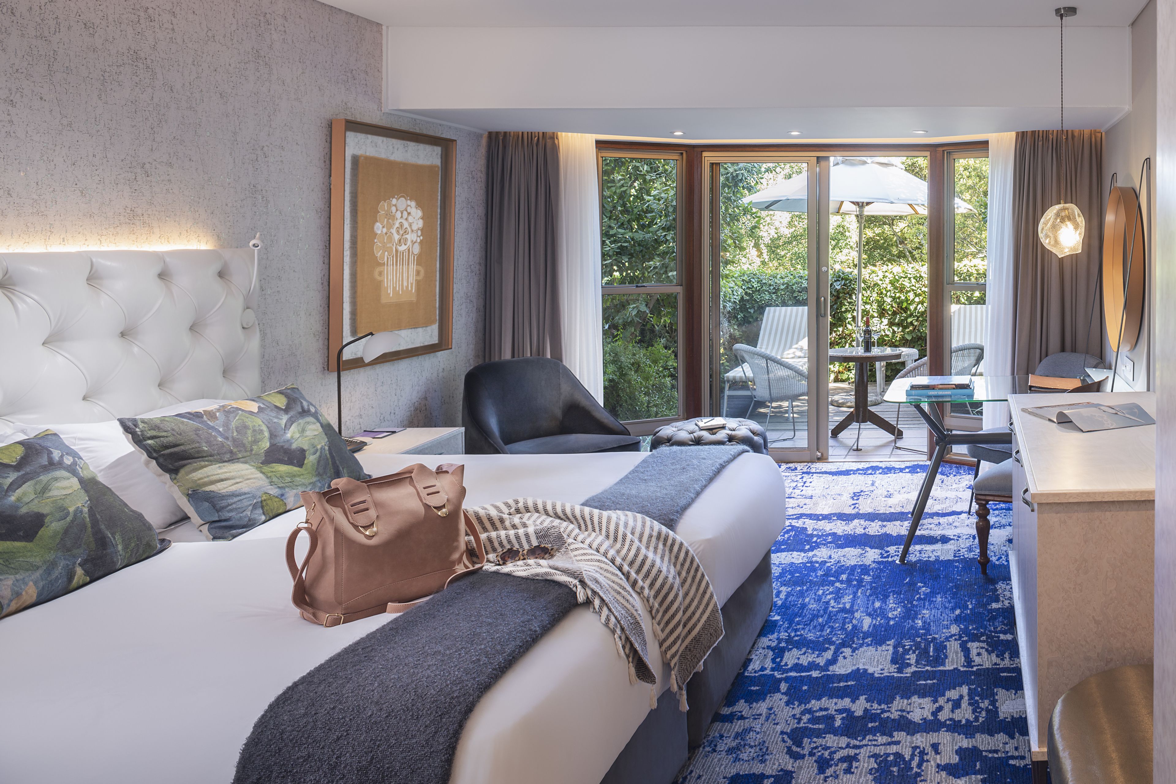 Una camera d'albergo con un letto grande, una scrivania, una sedia e vista sull'esterno.