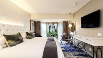 Una habitación de hotel con una cama grande, un escritorio y un televisor.