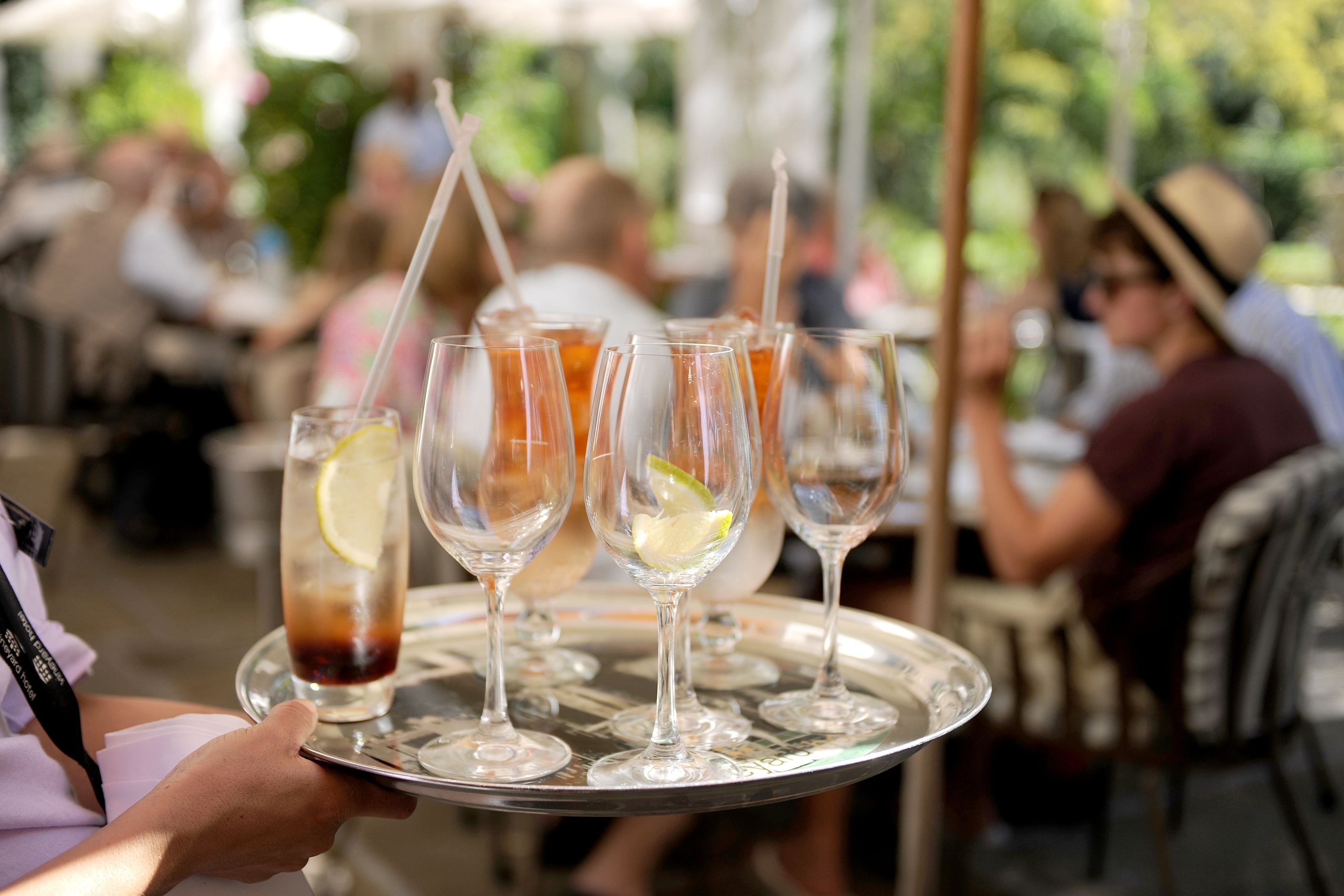 A tray with several glasses of iced tea and lemon slices.