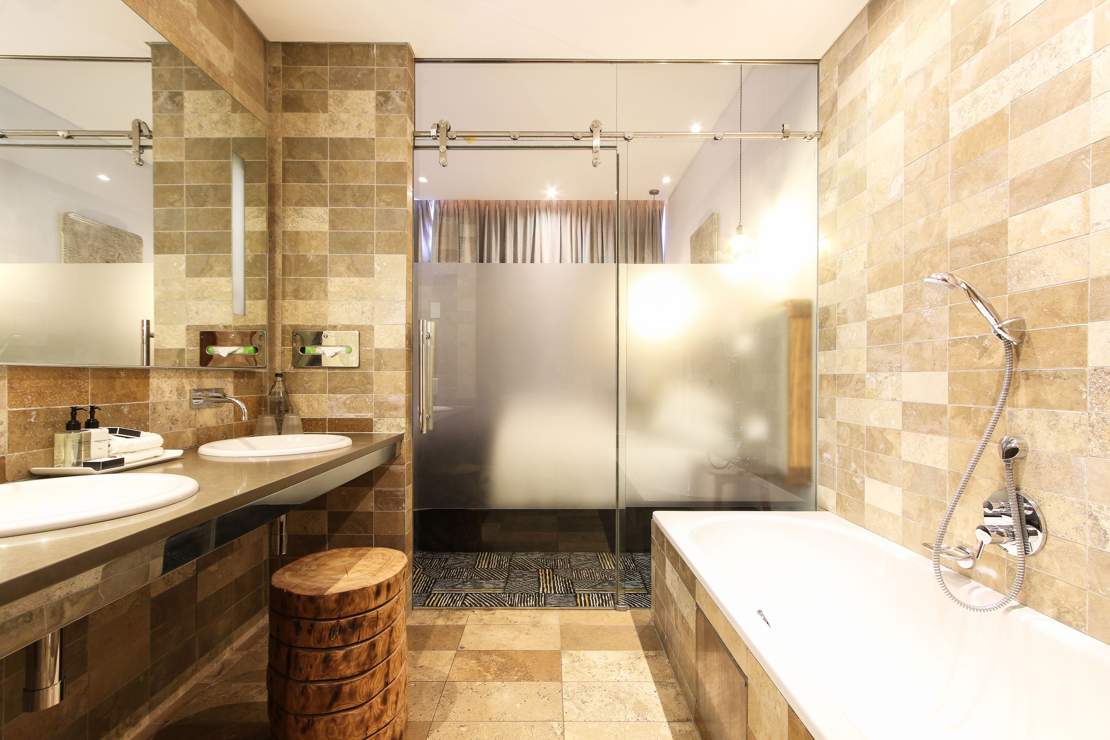 Une salle de bain moderne avec deux lavabos, une douche et une baignoire.