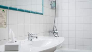 A bathroom with a white sink, a mirror, and a shower.