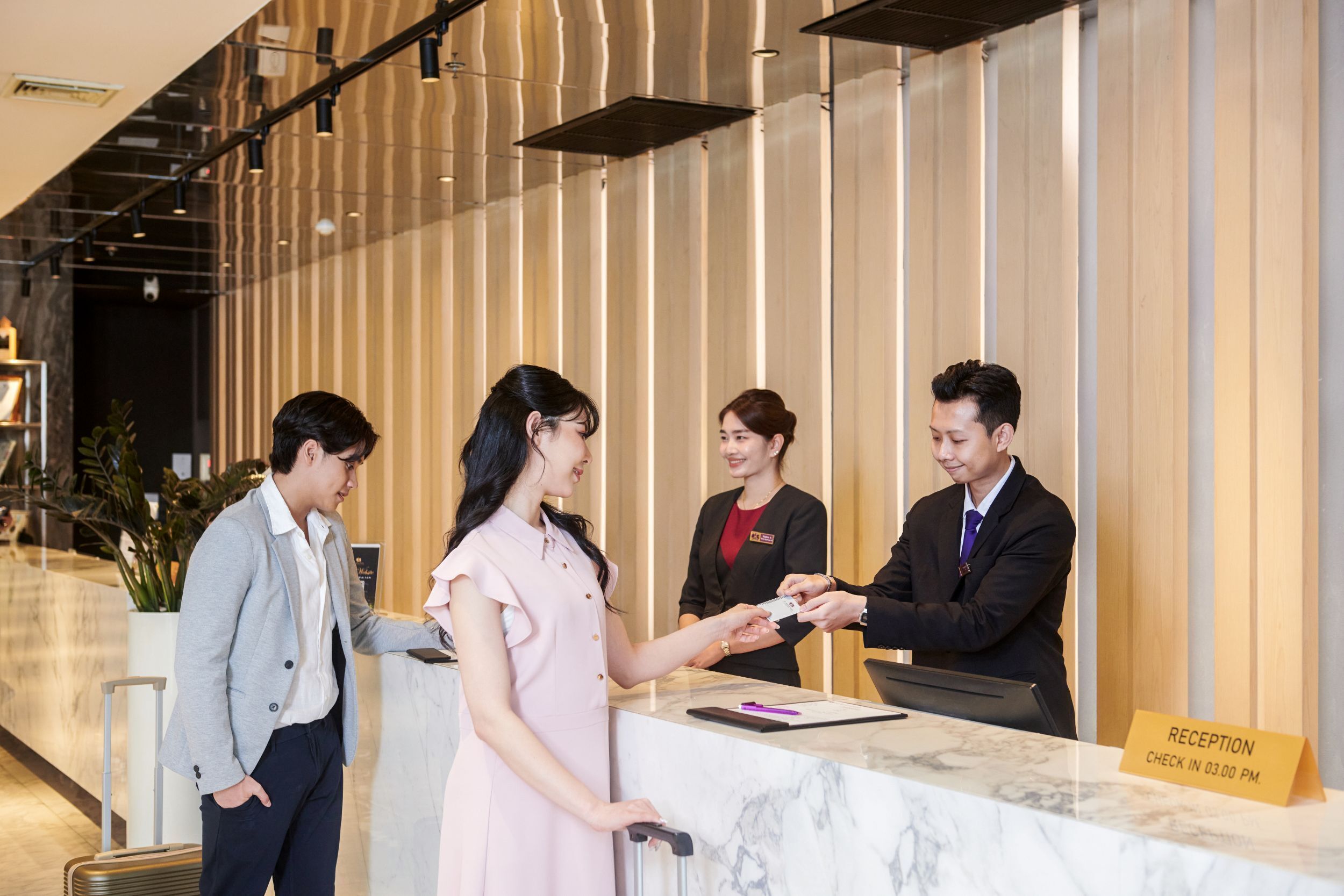 Uma mesa de recepção com uma placa indicando o horário de check-in às 15h.