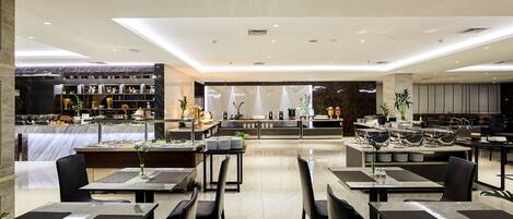 A modern restaurant with a marble counter, black chairs, and a central seating area with a white tablecloth.