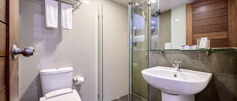 A modern bathroom with a glass-enclosed shower, a white sink, and a toilet.