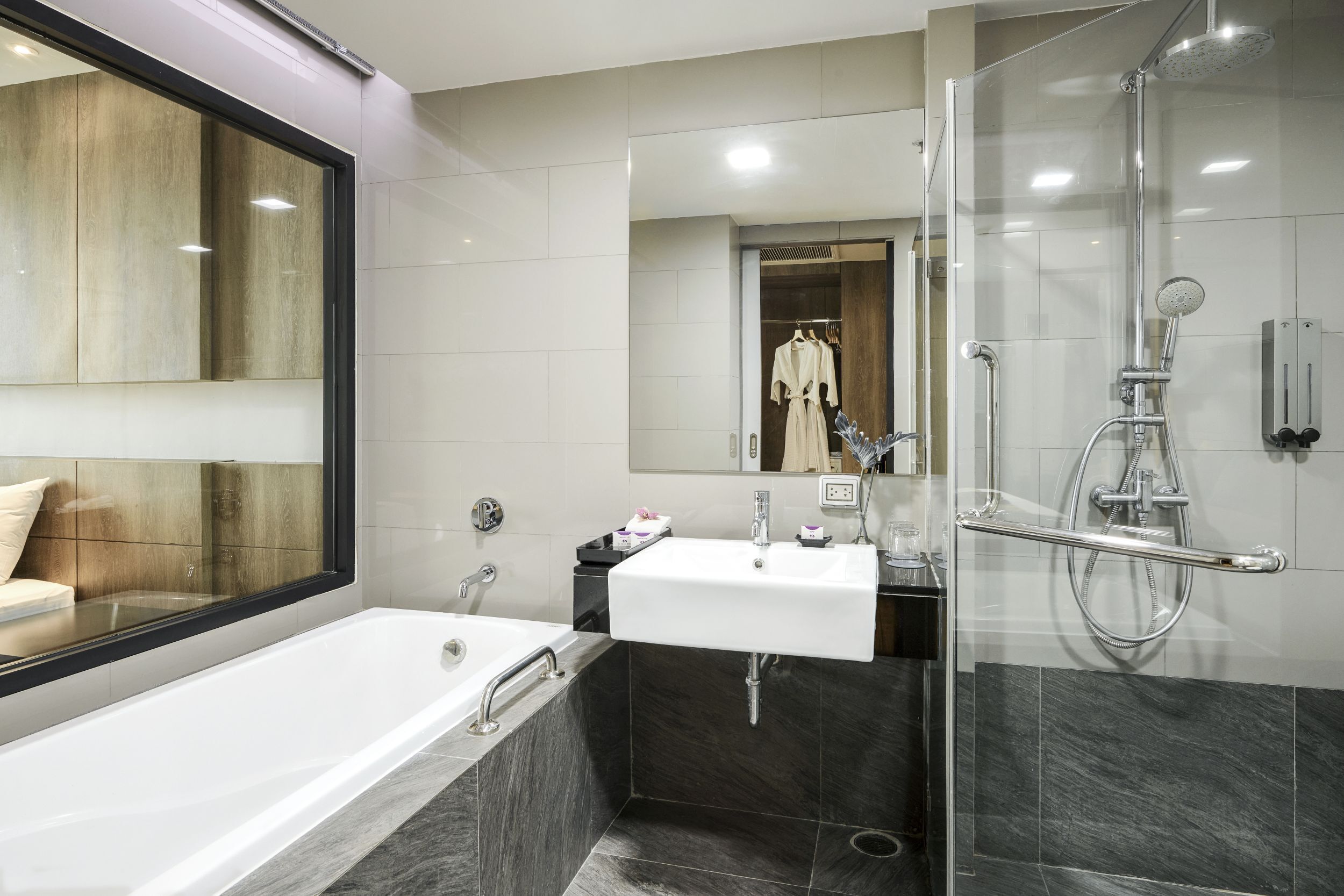A modern bathroom with a bathtub, a sink, and a glass-enclosed shower area.