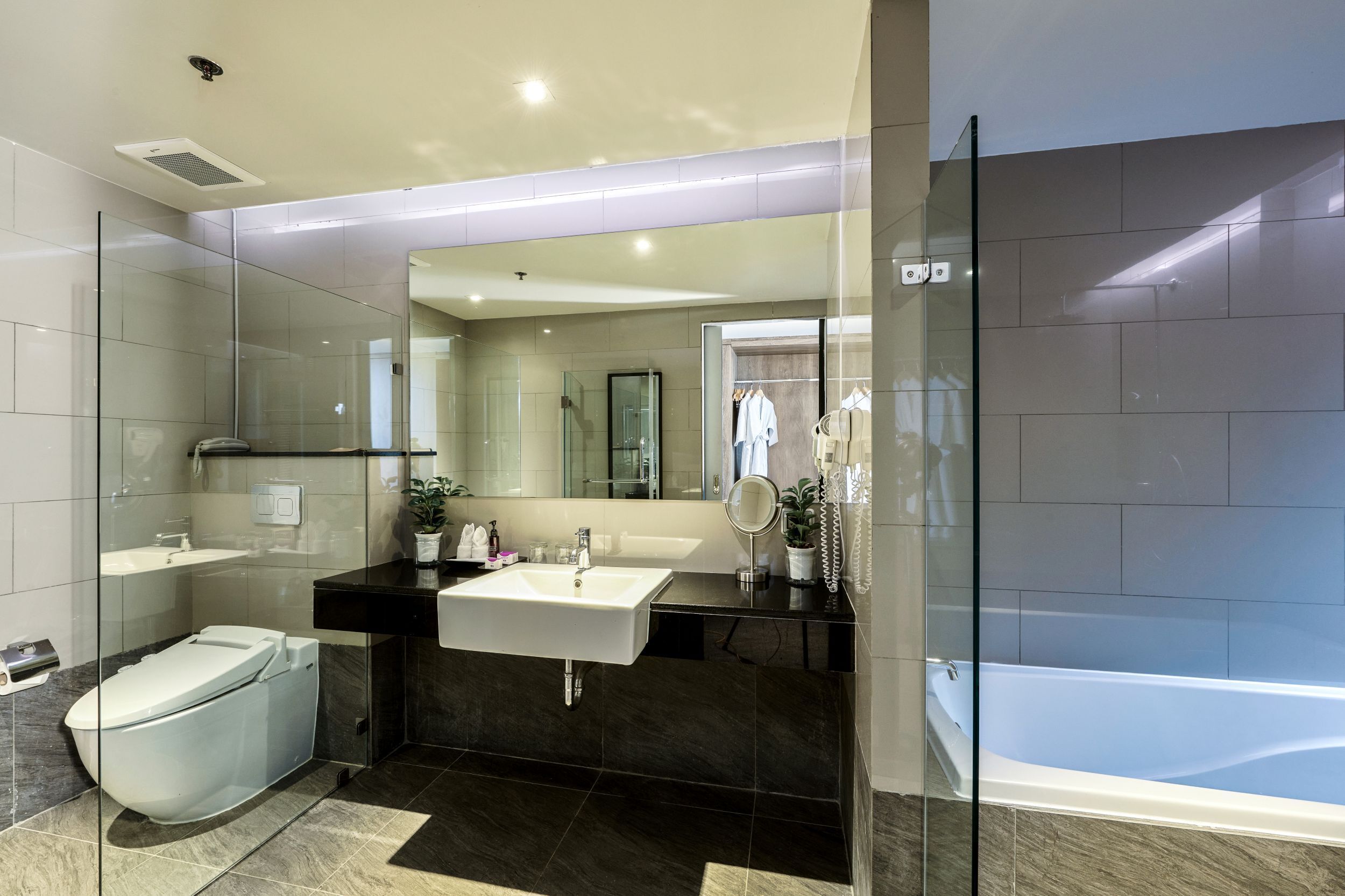 A modern bathroom with a glass-enclosed shower, a white sink, and a bathtub.