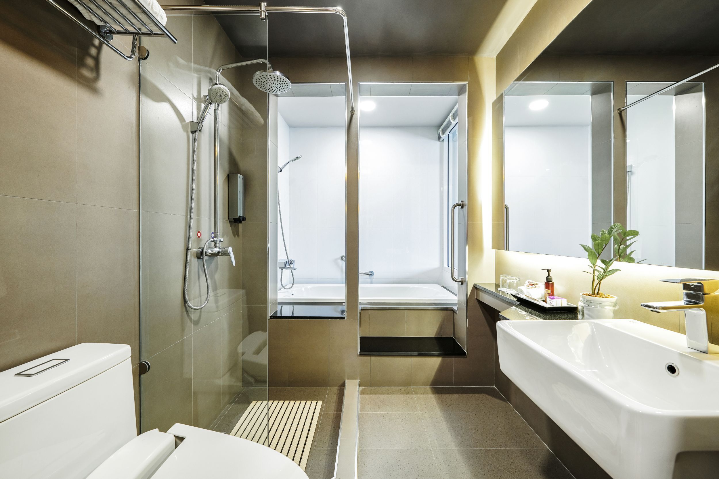 Un baño moderno con ducha envuelta en vidrio, una bañera blanca y un lavabo con espejo.