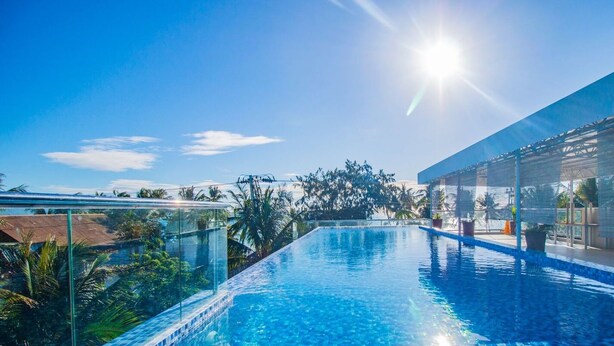 Un cielo azul despejado, una piscina y un edificio de diseño moderno.