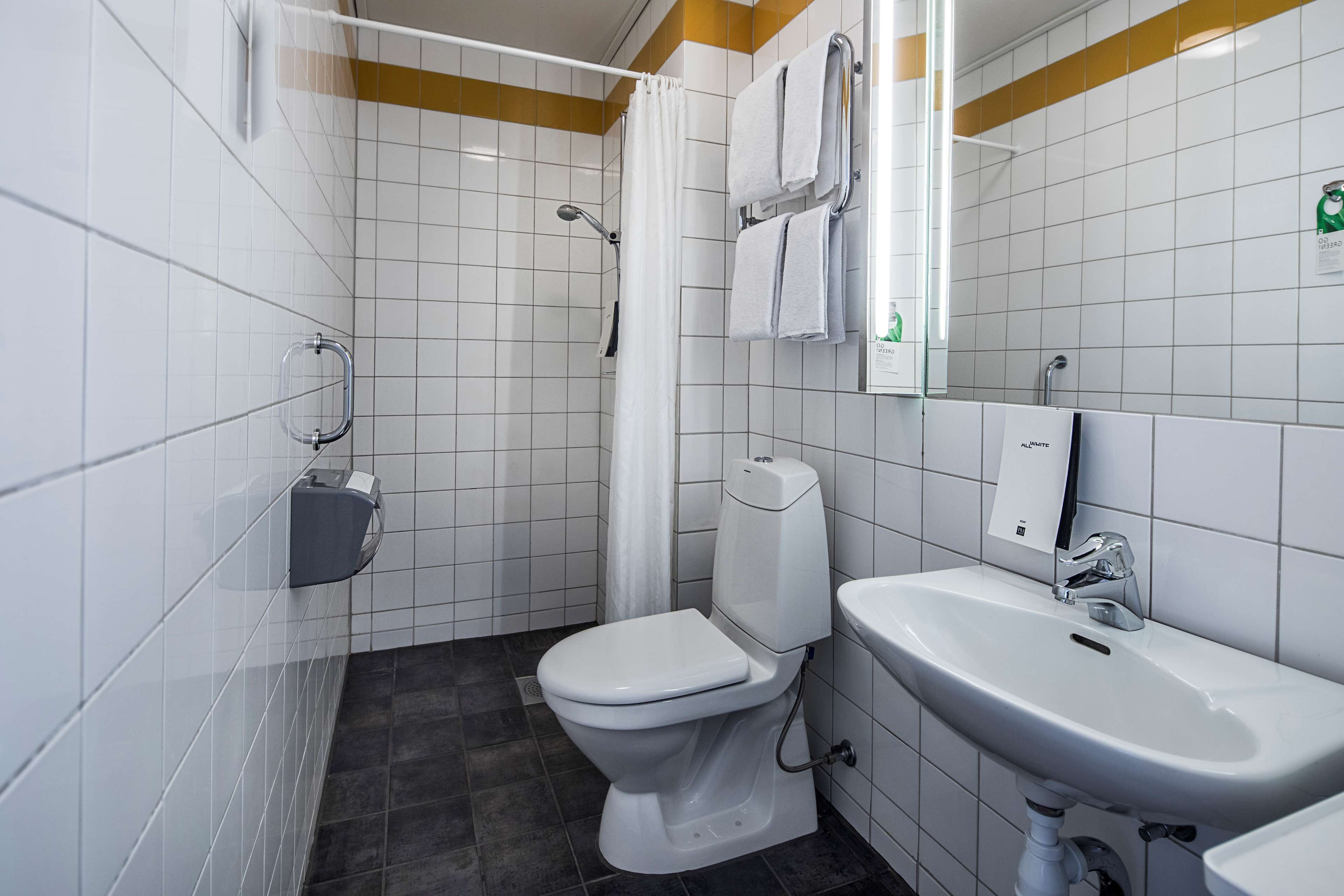 A modern bathroom with a toilet, shower, and sink.