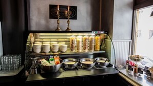 A buffet setup with various food items and utensils.