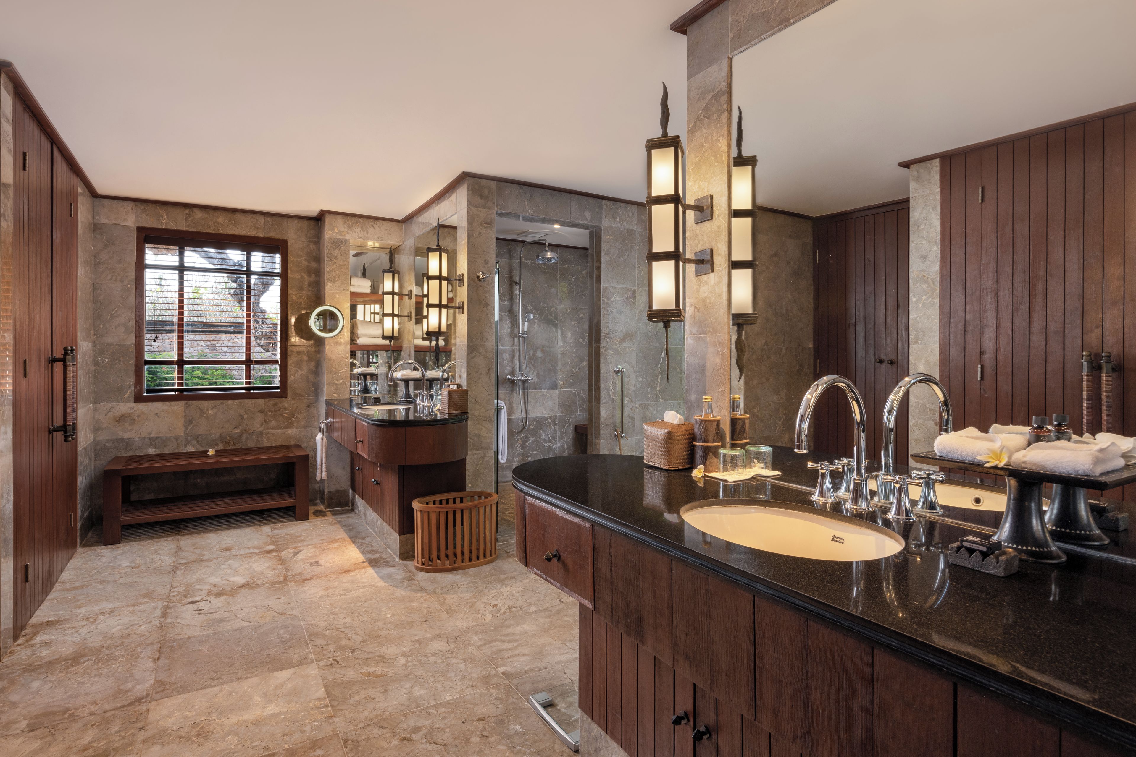 A bathroom with a large mirror, a bathtub, and a vanity with a sink.