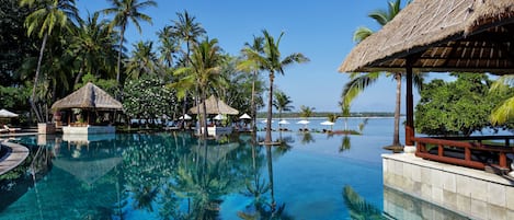 Una piscina al aire libre, camas de piscina gratis, sombrillas
