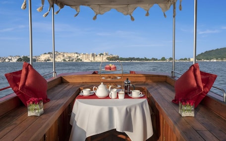 A table set for tea on a boat with a city view in the background.